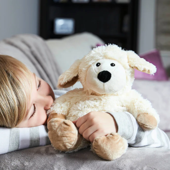 Child hugging Warmies Sheep Heatbag Plushie