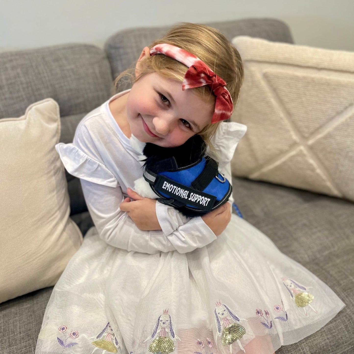 Girl smiling and hugging a Brave plushie