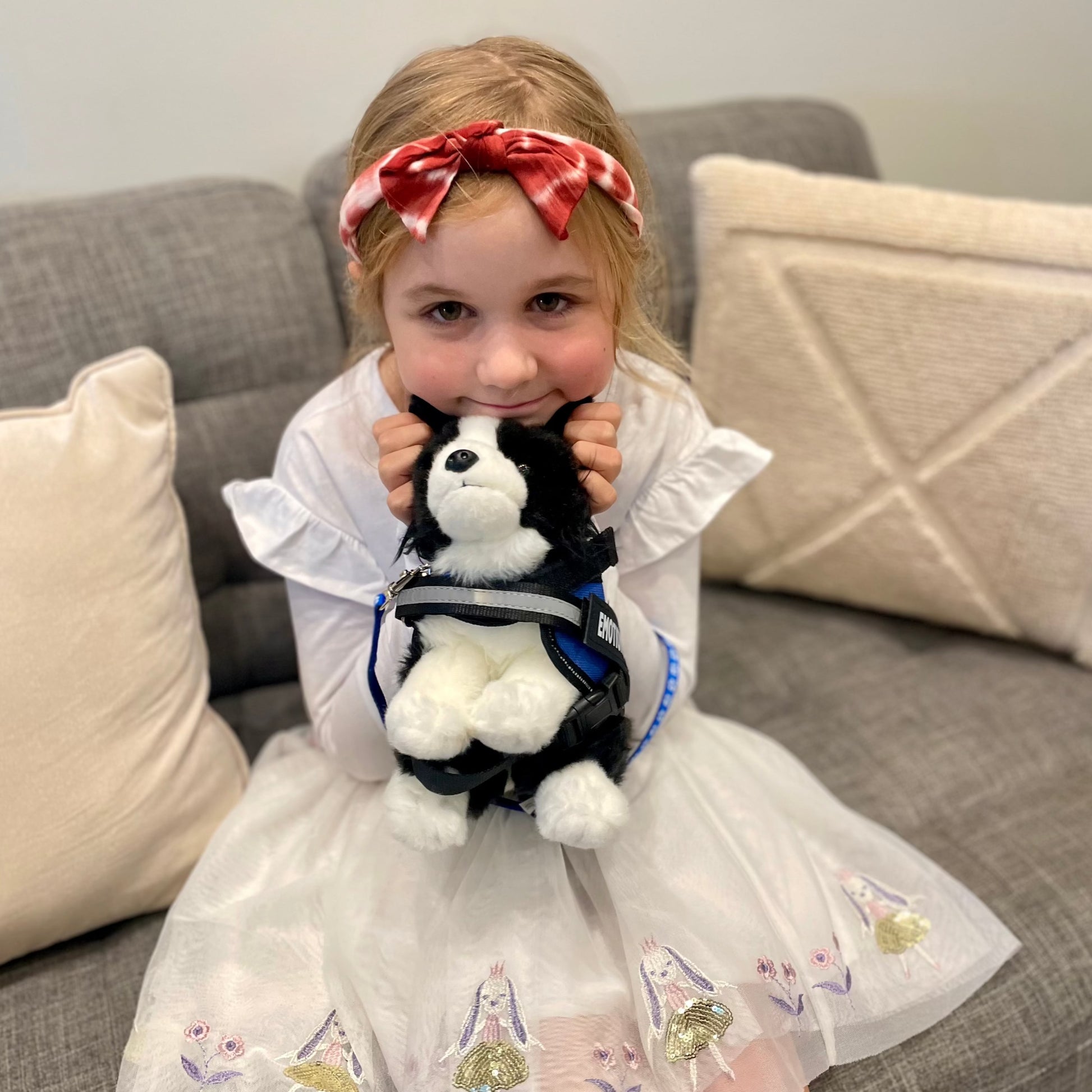 Girl smiling and hugging a Brave plushie