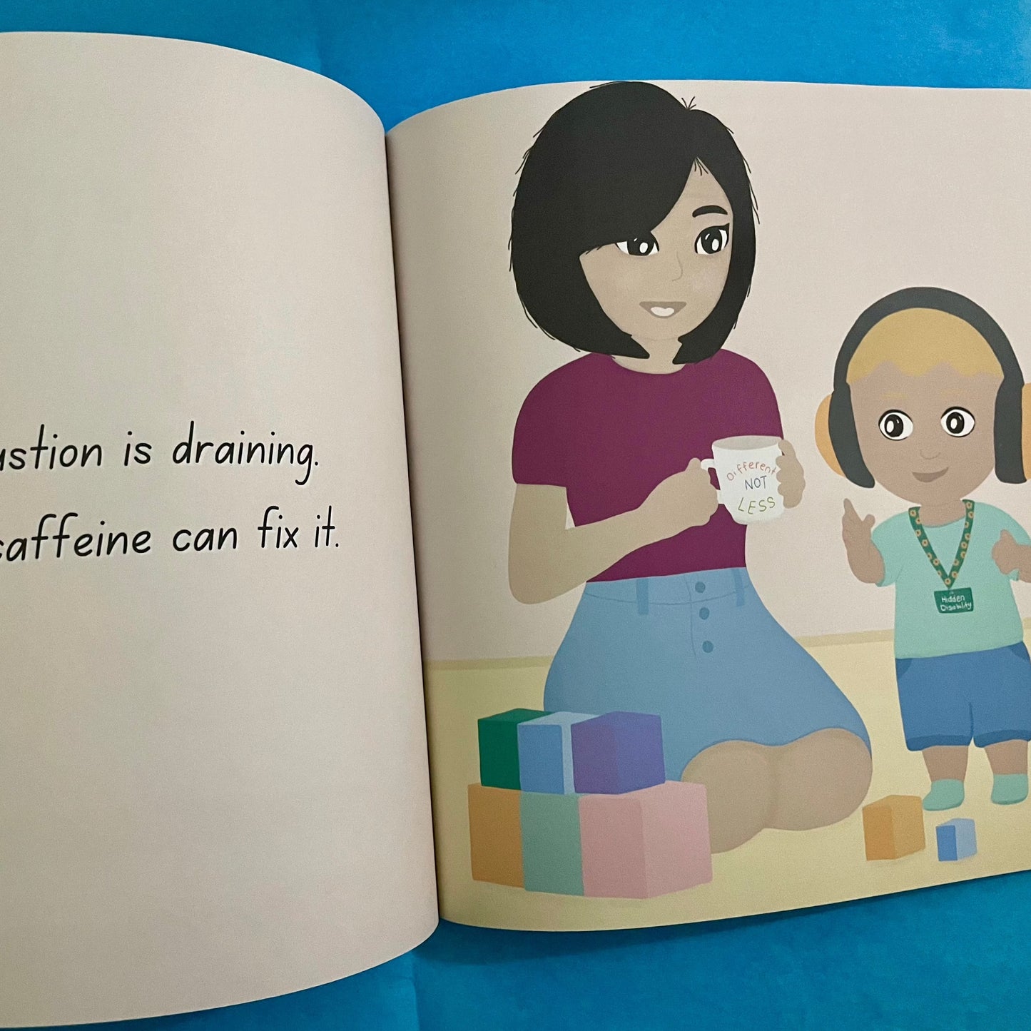 Inside pages of a book called Medical Mama. Page shows a mum holding a coffee cup next to a toddler playing with blocks wearing noise cancelling headphones and a sunflower lanyard.