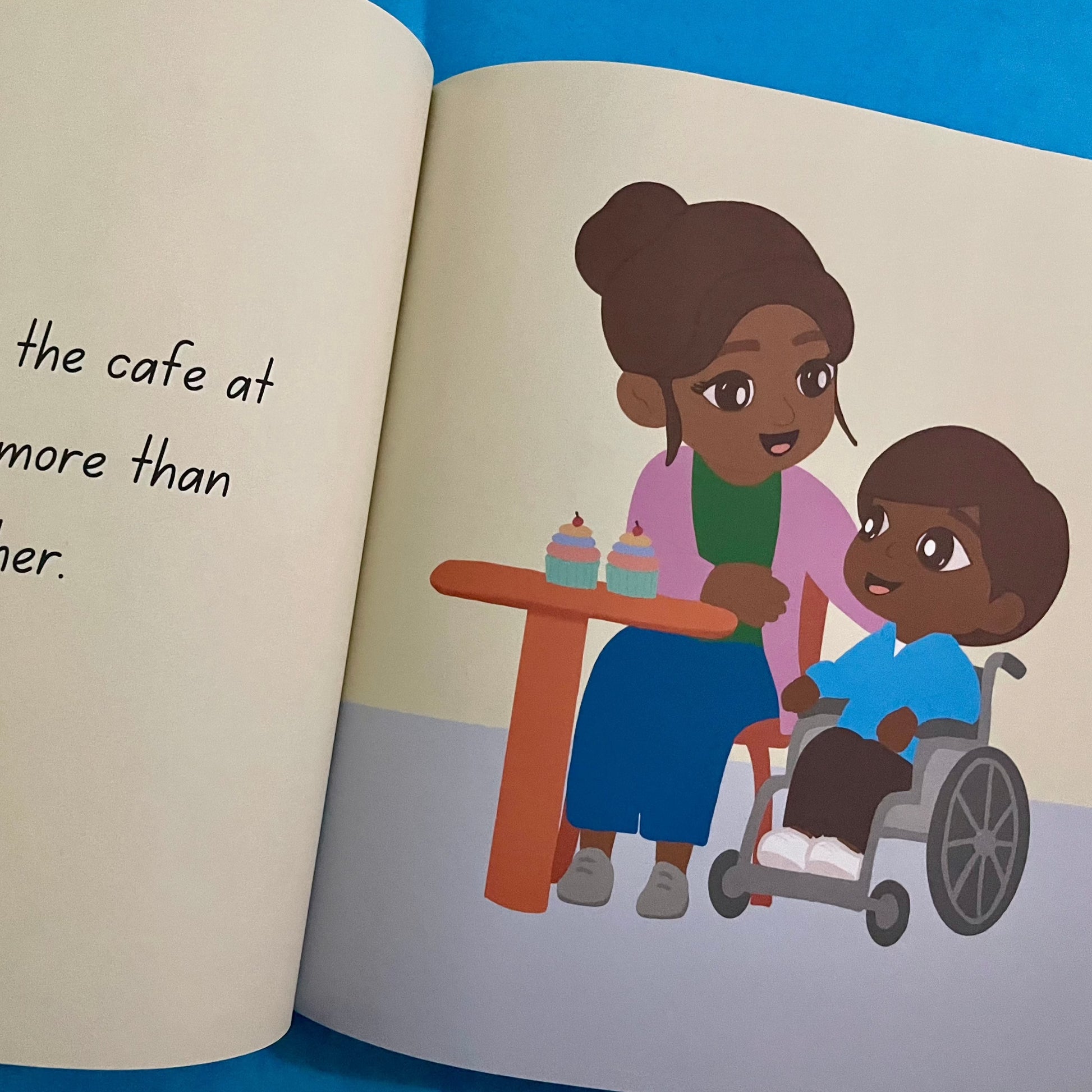 inside the book Medical Mama. Page shows a mum and boy in a cafe. The boy is in a wheelchair.