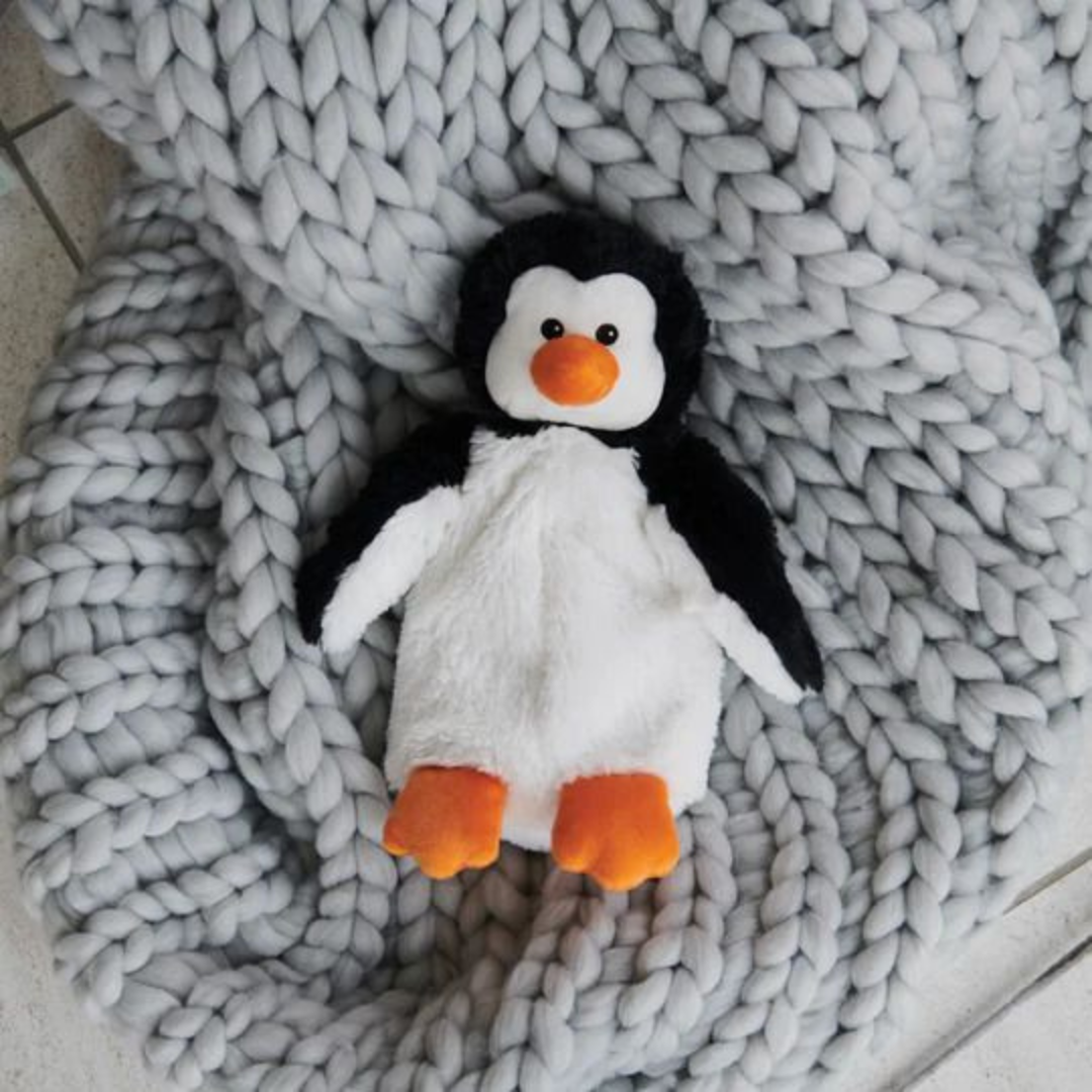 Plush penguin toy on a textured gray blanket